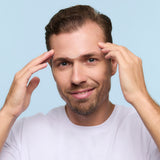 Man with a white strip on his forehead against a light blue background